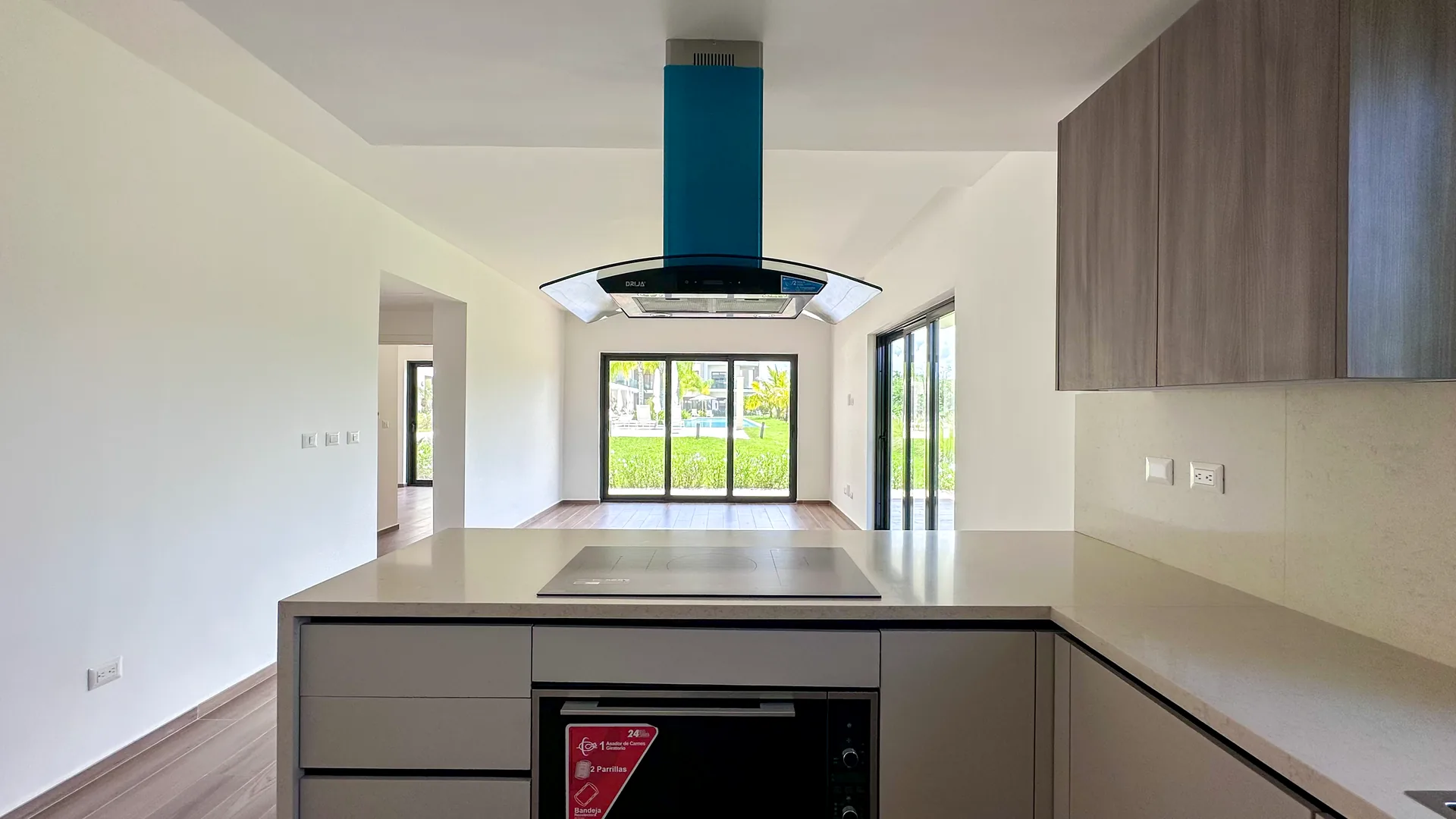 Cana Cove · Garden Residence A-101 — Kitchen island with view to the terrace