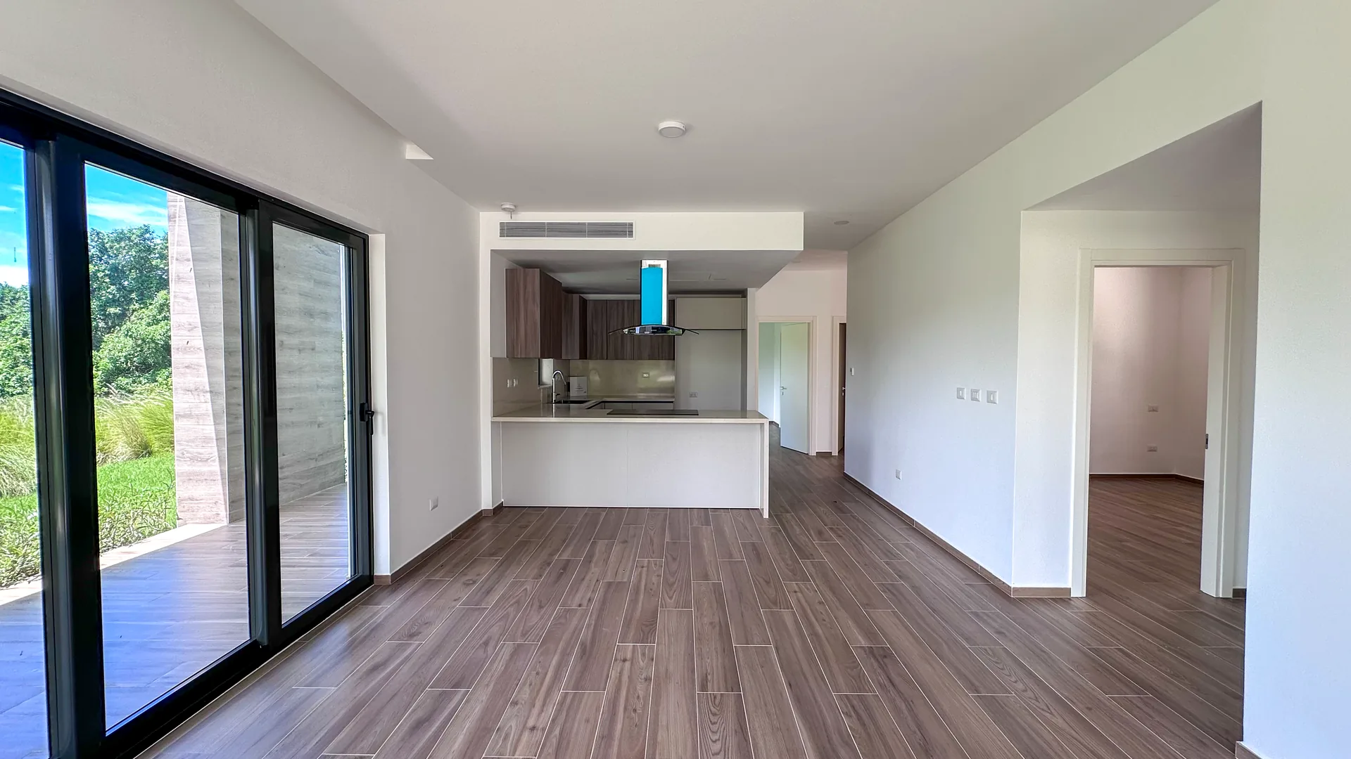 Cana Cove · Garden Residence A-101 — Living room with floor-to-ceiling sliding doors