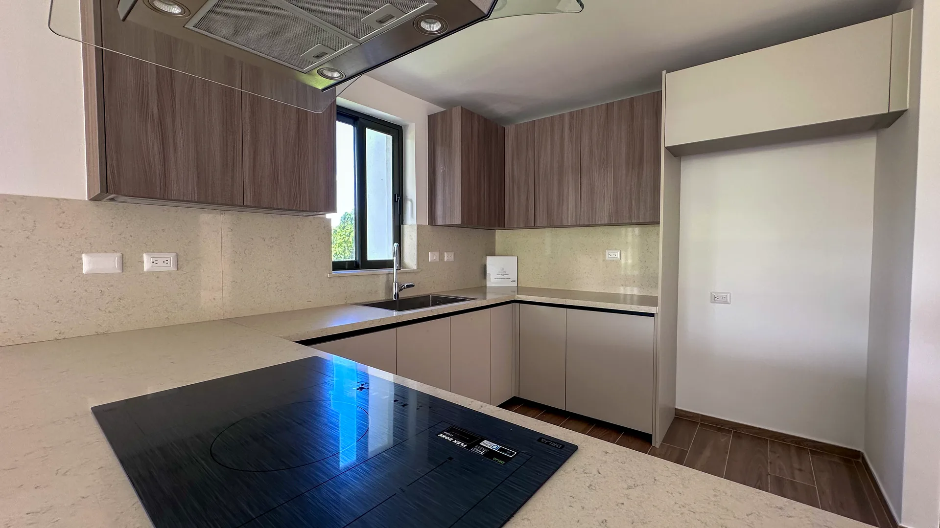 Cana Cove · Garden Residence A-101 — Quartz worktops and wood-finish cabinetry