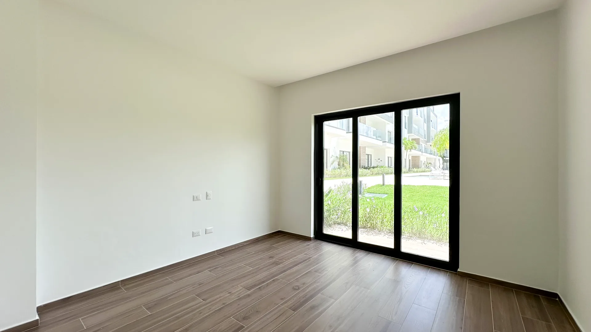 Cana Cove · Garden Residence A-101 — Second bedroom opening onto the green