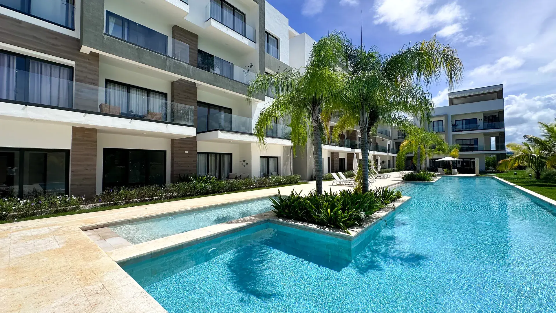 Cana Cove · Garden Residence A-101 — Pool and palms framed by the residences