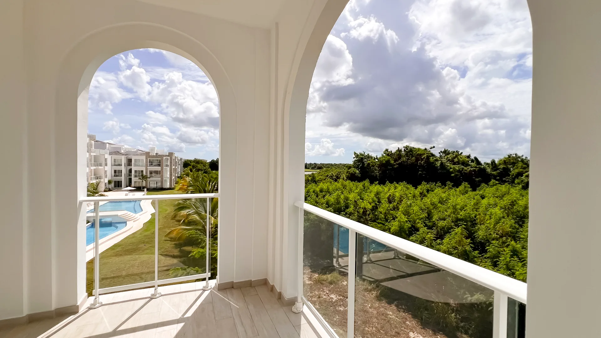 Cana Pearl · Rooftop Residence N-302 — Arched balcony overlooking the pool and the greens