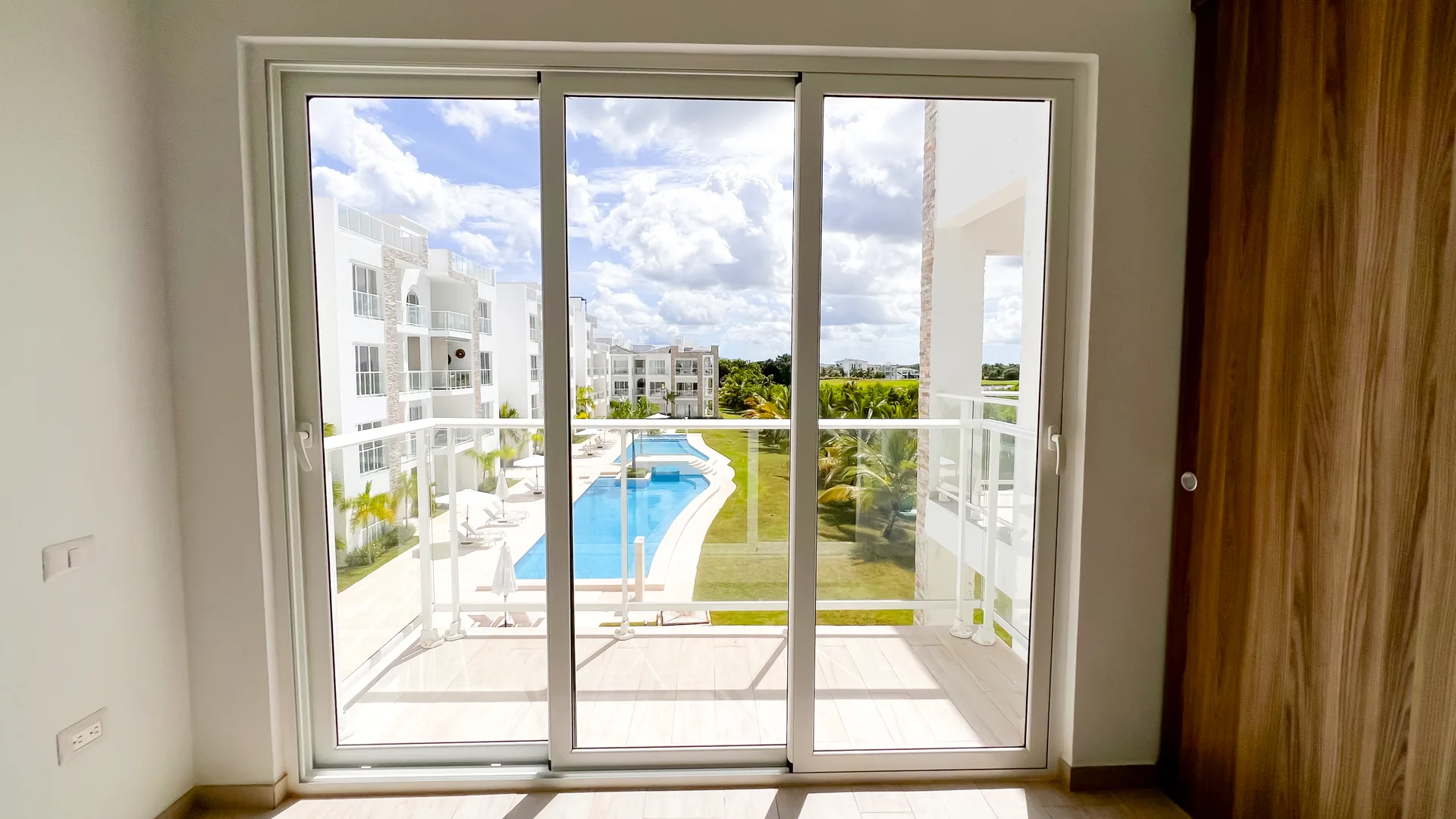 Cana Pearl · Rooftop Residence N-302 — Bedroom opening onto the balcony and pool view