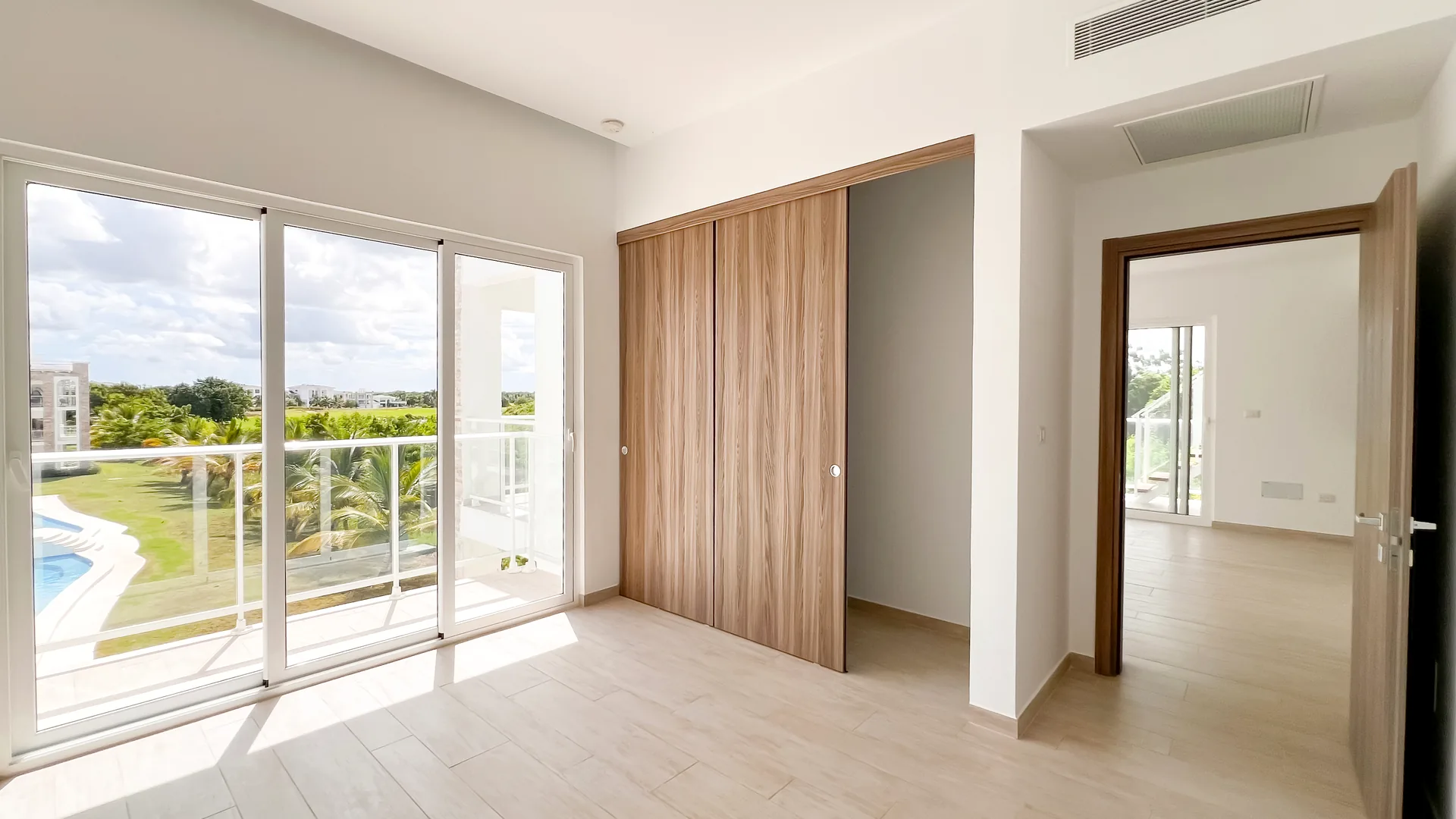 Cana Pearl · Rooftop Residence N-302 — Second bedroom with wood-finish wardrobes