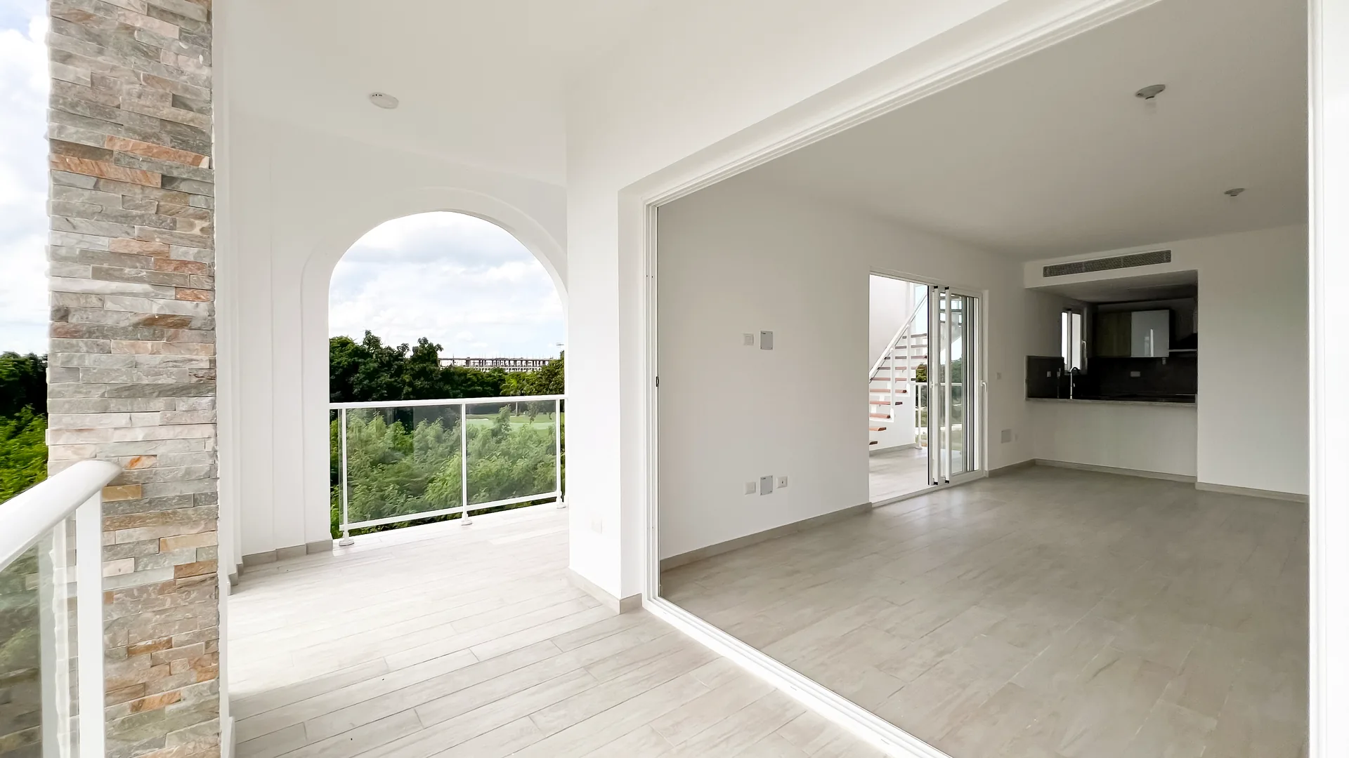 Cana Pearl · Rooftop Residence N-302 — Balcony arches framing the living room