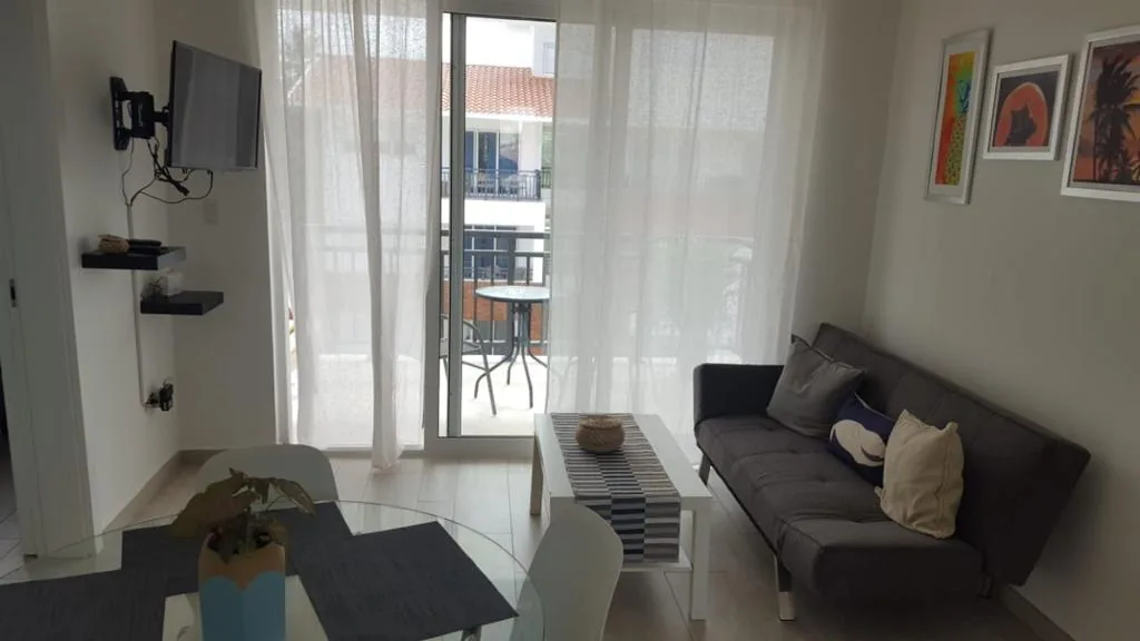Coral Village · Apartment B-3-B — Living room with sofa and terrace access
