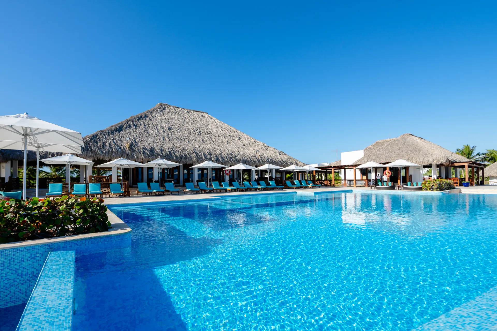 Poseidonia Residences — Beach club pool with palapas at Cana Bay